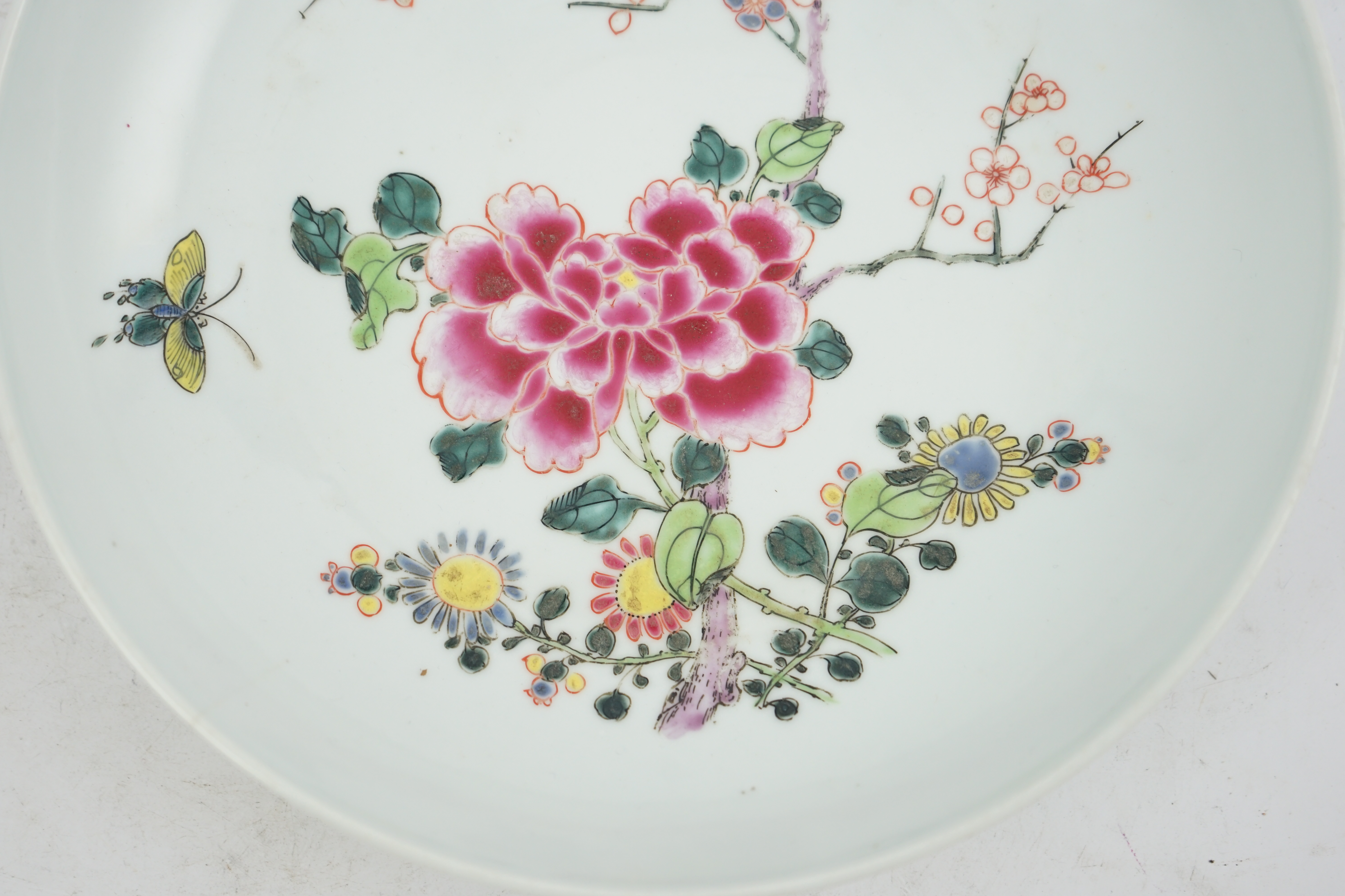 A Chinese famille rose ‘peony and prunus’ saucer dish, Yongzheng mark and period (1723-35)